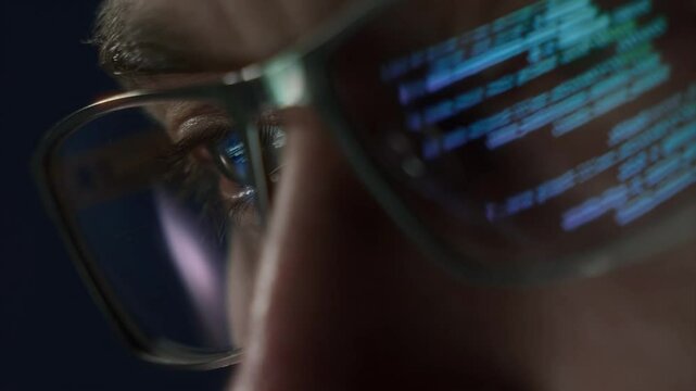 Extreme close-up of a programmers eye with computer code reflecting on glasses, symbolizing cybersecurity, coding, and software development. 