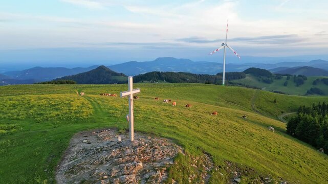 Aerial view of serene pasture with grazing cows and wind turbines in the picturesque Grazer Bergland, Sommeralm, Styria, Austria.