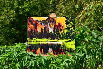 A vibrant painting displayed outdoors, placed on an easel amidst a beautiful natural landscape,...