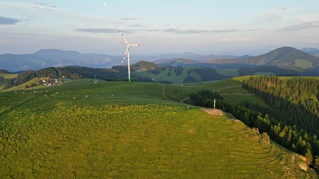 Aerial view of scenic wind turbines amidst peaceful mountains and lush pastures, Sommeralm, Styria, Austria.