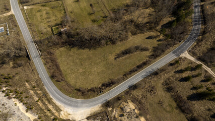 Aerial perpendicular view of a road with a curve in the countryside.