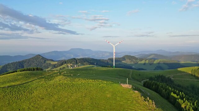 Aerial view of alpine pasture with windmill and scenic mountains, Sommeralm, Styria, Austria.