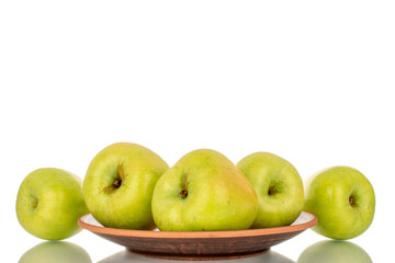 Several sweet green apples with a clay plate, close-up, isolated on a white background.