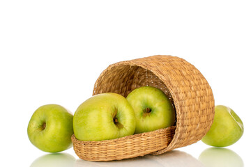 Several sweet green apples in a straw basket, close-up, isolated on a white background.