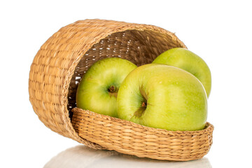 Several sweet green apples in a straw basket, close-up, isolated on a white background.