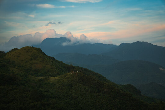 Mountain Range with a blue sky and clouds overlapping the peak of the background mountain at treasure mountain, tanay, philippines