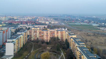 Fototapeta premium city ​​landscape in poland in the morning. aerial view of sunrise in the city of Kalisz. illuminated apartment blocks, skyscrapers and streets.