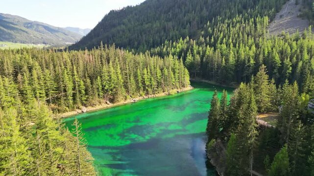 Aerial view of tranquil green lake surrounded by lush forest and majestic mountains, Gruner See, Bruck an der Mur, Styria, Austria.