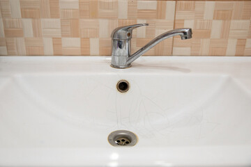  A white sink in the bathroom or toilet with cracks in the form of a spider web.