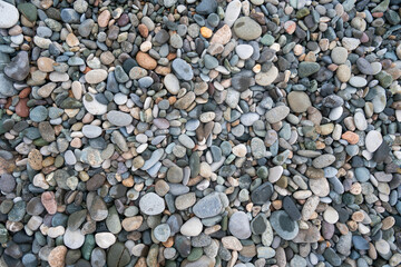 Texture of wet small pebbles of rocks on the beach