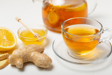 Cup of hot ginger tea with slices of ginger root on wooden background. Warming drink. Alternative medicine. Tea with honey, lemon, ginger and mint. Space for text. Copy space