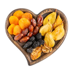 Mix of dried fruits in wooden heart-shaped bowl isolated on white. Top view.
