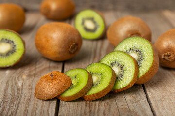 Kiwi on wooden background. Whole fruit and slices pieces of green kiwi on table. fresh ripe juicy...