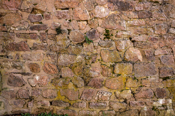 Fototapeta premium Architectural stone wall with white mortar joints and rugged brown rocks. For the background of your photos and collages