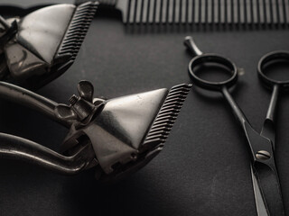 A collection of vintage barber tools is displayed, including clippers, scissors, and combs. The setting suggests a professional barbershop atmosphere, perfect for grooming