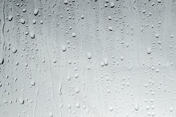Water drops on light glass surface, top view
