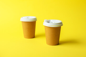 Paper cups on yellow background. Mockup for design