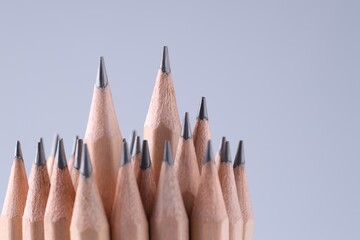 Many pencils on light grey background, closeup. Space for text