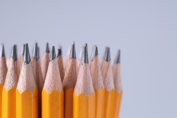 Many pencils on light grey background, closeup. Space for text