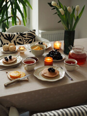 Hygge breakfast. Pancakes, fruits, tea. Cozy Morning
