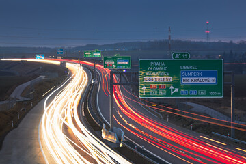 Highway D11 near exit 95, Hradec Králové, during evening rush hour, with long exposure of moving cars, traffic signs visible.