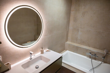 Salle de bain moderne avec carrelage élégant, baignoire design et robinetterie haut de gamme,...