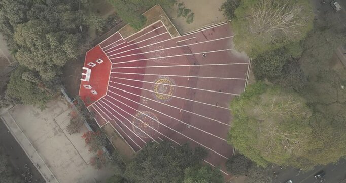 Aerial view of central shaheed minar surrounded by trees and geometric patterns in pavement, Shahbag, Dhaka, Bangladesh.