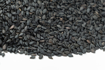 Black organic sesame seeds close-up on white background
