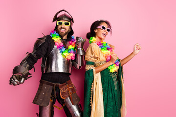 Two people in themed fantasy costumes having fun on pink background