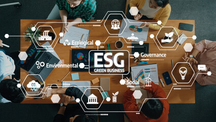 Aerial View of Diverse Business Team Collaborating on ESG Initiatives at a Green Business Meeting with Charts and Digital Graphics. Amity