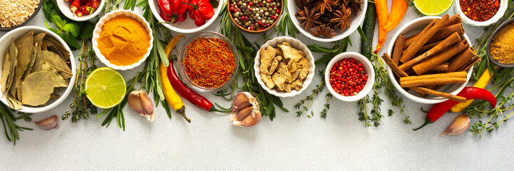 A vibrant assortment of spices and herbs on a gray background, offering a flavorful addition to any...