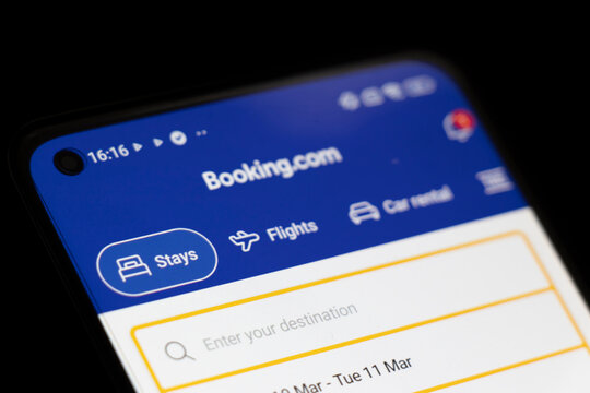 Warsaw, Poland - March 10, 2025: Close-up of smartphone displaying Booking.com homepage for travel bookings, featuring options for stays and flights.
