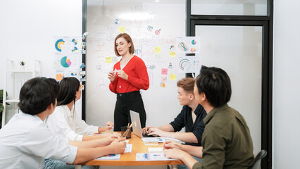 Young beautiful leader presents marketing strategy while expert investor and project manager listening and lecturing to analyze business performance at start up business meeting. Immaculate.