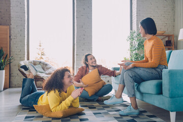 Friendly group of diverse young adults enjoying casual time together in a comfortable living room...