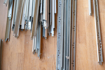 Barres de placo pos&eacute;es au sol sur un parquet dans un chantier de r&eacute;novation, illustrant la pr&eacute;paration des travaux d&rsquo;am&eacute;nagement int&eacute;rieur.