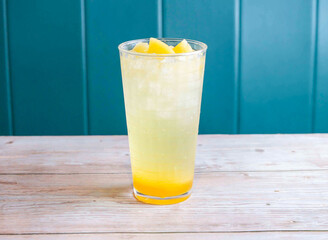 Pineapple Soda with ice cube served in glass isolated on wooden background side view of Hong Kong drink