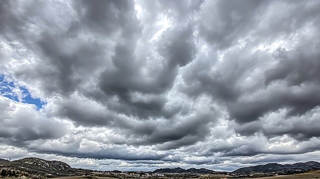 Overcast sky over mountains and town, background dramatic