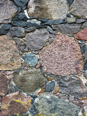 The texture of the split stones. Background with gray, brown, and red stones. Rock structure. Natural building material