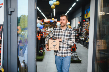 A man in a hardware store choosing a tool