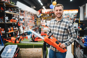 Man is choosing electric saw in tools store