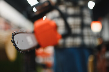 Man is choosing electric saw in tools store