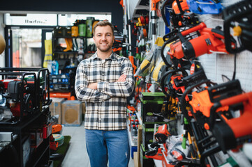 A man in a hardware store choosing a tool
