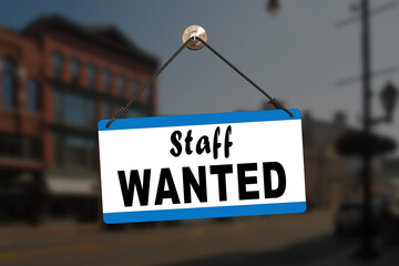 Close-up on a red and white sign in a window with written the message - Need staff urgently. Job recruitment concept.