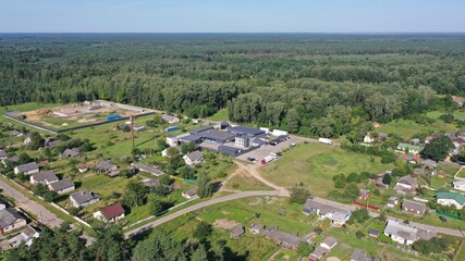 Rural settlement near a huge forest coniferous vastness in summer. A village on the edge of a huge...