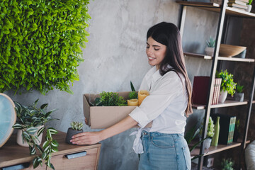 Young woman arranging home decor in a cozy room with indoor plants
