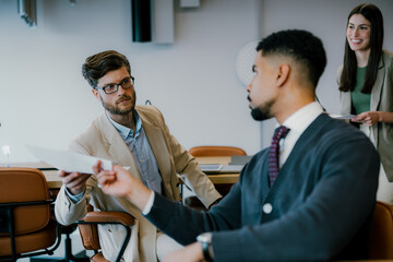 Mid adult male communicating with his colleague during a meeting in the office.
