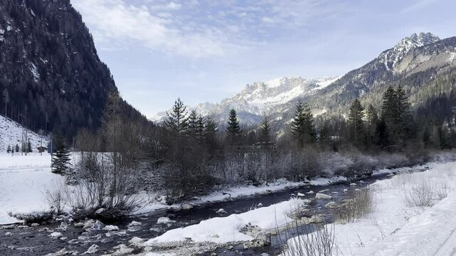 Outside Landscape of Stream and Mountains in Campitello di Fassa. Valley Scenery during Winter Day in Italy.
