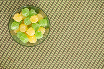 green and yellow gummies on a checkered background