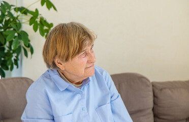 old woman sits alone sad. Selective focus.