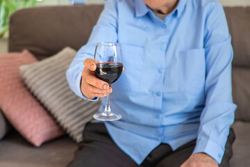 Old woman drinking wine. Selective focus.
